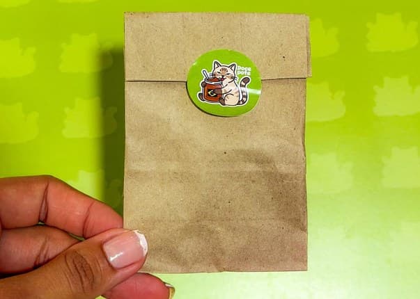Bolsa de papel kraft cerrada con el sticker del gato de Doce pote